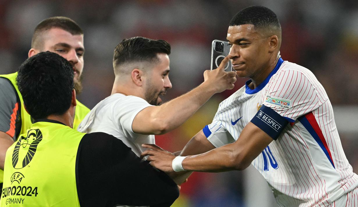 Mbappe tampak kebingungan dan tidak terkesan dengan usahanya untuk berfoto dengannya saat ia memberi isyarat agar meninggalkan lapangan. (Fabrice COFFRINI / AFP)