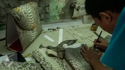 Pekerja menyelesaikan pembuatan produk berbahan dasar kulit ular di bengkel kerja, Cibitung, Jawa Barat, Jumat (24/3). Hasil produk berbahan dasar kulit ular tersebut telah di ekspor ke beberapa negara di Asean. (Liputan6.com/Gempur M Surya)