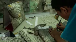 Pekerja menyelesaikan pembuatan produk berbahan dasar kulit ular di bengkel kerja, Cibitung, Jawa Barat, Jumat (24/3). Hasil produk berbahan dasar kulit ular tersebut telah di ekspor ke beberapa negara di Asean. (Liputan6.com/Gempur M Surya)
