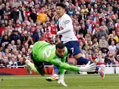 Pemain Tottenham Hotspur Son Heung-min mencetak gol ke gawang Arsenal yang dijaga oleh David Raya pada pertandingan sepak bola Liga Inggris di Emirates Stadium, London, Inggris, Minggu (24/9/2023). Pertandingan berakhir imbang dengan skor 2-2. (AP Photo/David Cliff)