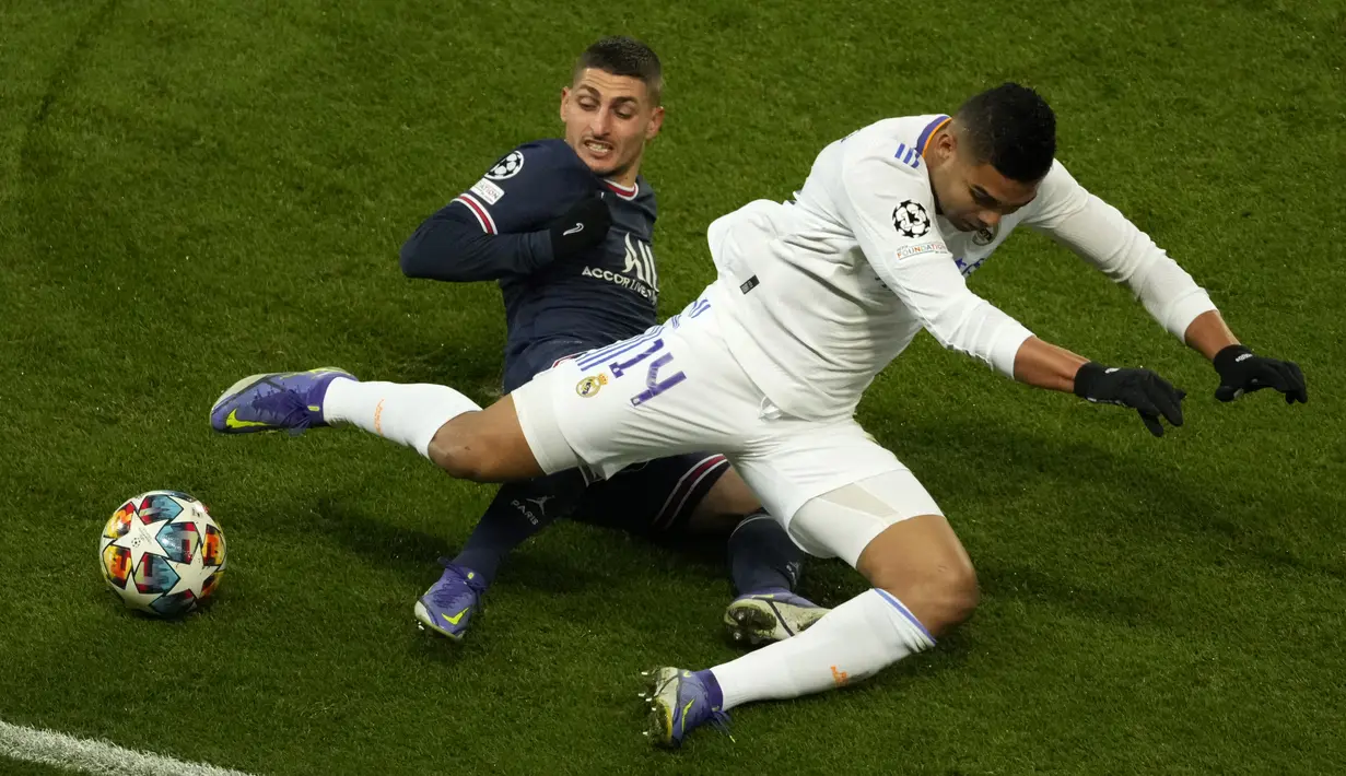 Gelandang Real Madrid Casemiro berebut bola dengan gelandang Paris Saint Germain (PSG) Marco Verratti pada leg pertama babak 16 besar Liga Champions di Stadion Parc des Princes, Rabu dini hari WIB (16/2/2022). PSG susah payah kalahkan Real Madrid 1-0. (AP Photo/Francois Mori)