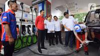 Presiden Joko Widodo (tengah) menyaksikan petugas mengisikan bahan bakar ke kendaraan saat meresmikan Implementasi Program Biodiesel 30 persen (B30) di SPBU MT Haryono, Jakarta, Senin (23/12/2019). Jokowi menargetkan implementasi program B40 pada 2020 dan B50 pada 2021. (Liputan6.com/Angga Yuniar)