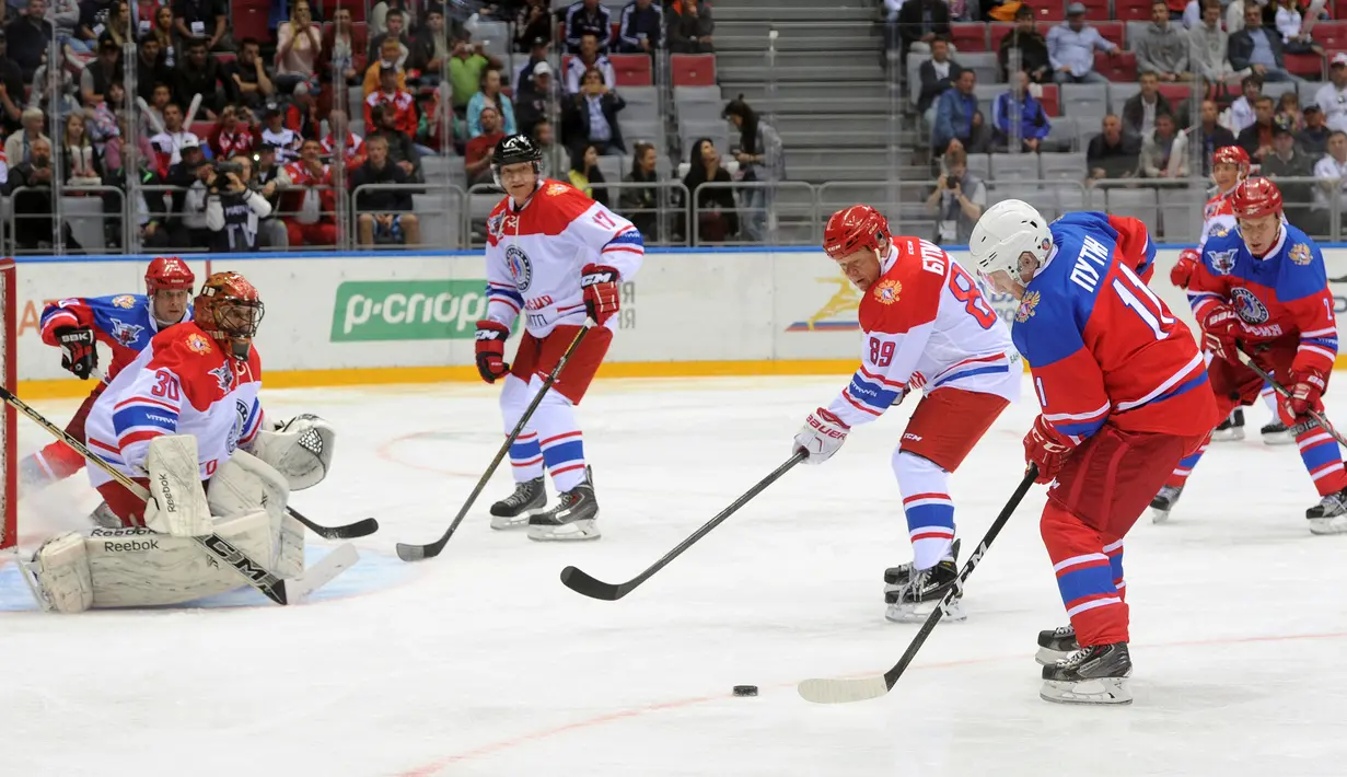 Presiden Rusia Vladimir Putin bersiap melakukan pukulan saat bermain hoki es dalam acara gala game Ice Hockey League di Sochi, Rusia, 10 Mei 2016. (Reuters/ Mikhail Klimentyev/Sputnik/Kremlin)