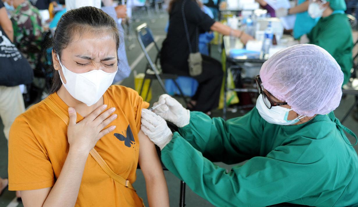 Seorang wanita menerima vaksin virus corona COVID-19 AstraZeneca di klinik vaksinasi massal darurat di Denpasar, Bali, Selasa (6/7/2021). Indonesia tengah memerangi gelombang infeksi baru yang belum pernah terjadi sebelumnya. (SONNY TUMBELAKA/AFP)