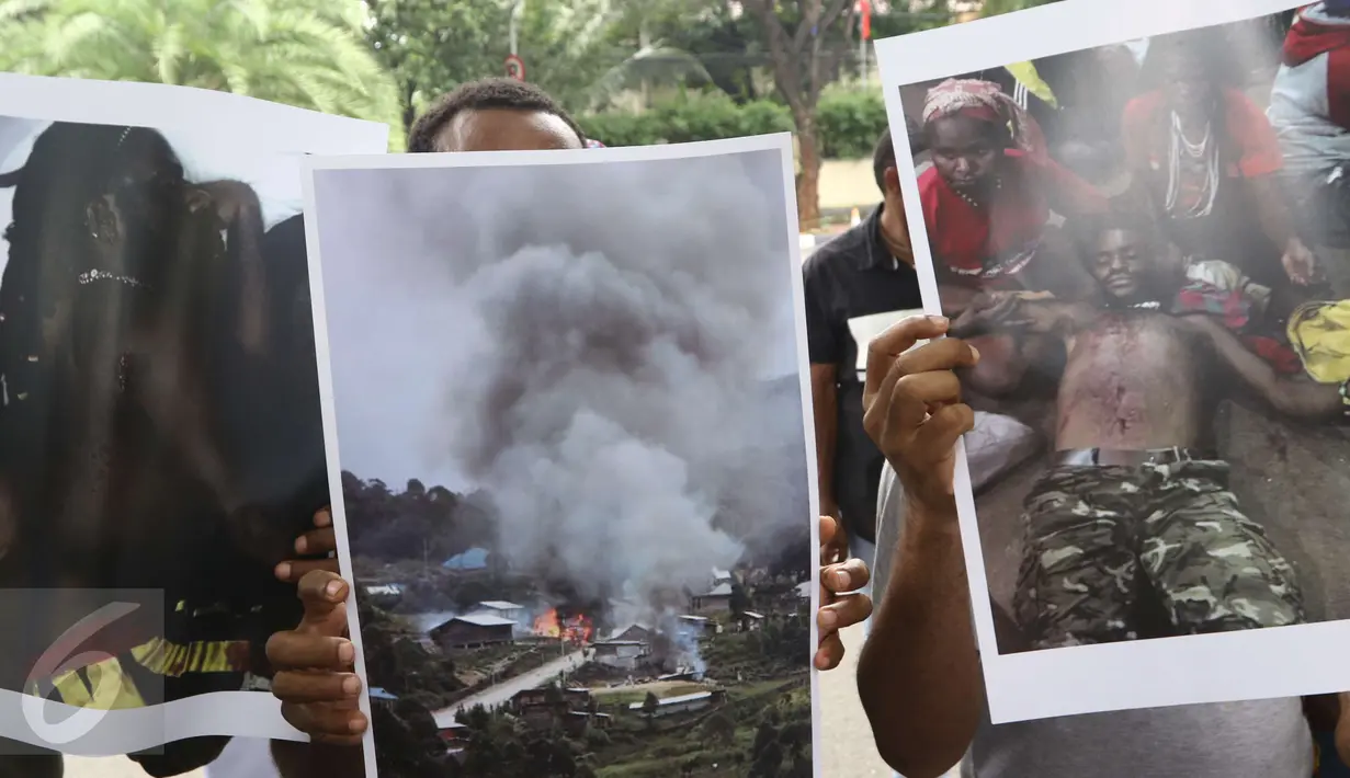 Mahasiswa membawa poster yang menggambarkan korban akibat konflik saat menggelar aksi di Gedung Komisi Pemilihan Umum (KPU) Pusat, Jakarta, Selasa (14/3). (Liputan6.com/Helmi Afandi)