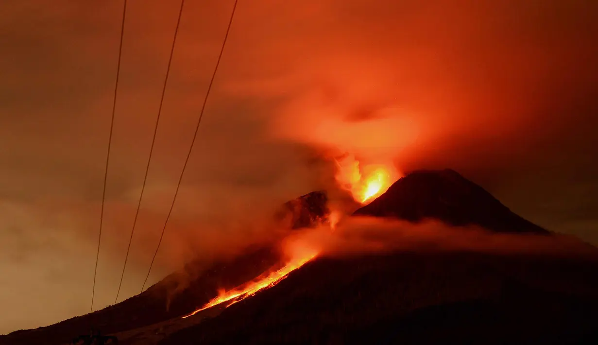 Foto yang diambil pada tanggal 13 Januari 2018 menunjukkan gunung Sinabung memuntahkan lahar pada malam hari di Karo. (AFP Photo/Lana Priatna)