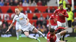 Pemain Swansea City, Sam Clucas (kiri) kesakitan saat di jegal pemain Manchester United, Victor Lindelof pada laga Premier League di Old Trafford, (31/3/2018).  Manchester United menang 2-0. (Anthony Devlin/PA via AP)