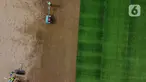 Pekerja melakukan proses perataan tanah untuk pemasangan rumput hybrid di area lapangan latih Jakarta International Stadium, Jumat (23/10/2020). Sebanyak dua lapangan latih JIS mulai dilakukan pemasangan rumput hybrid dan ditarget selesai pada Desember 2020. (Liputan6.com/Helmi Fithriansyah)