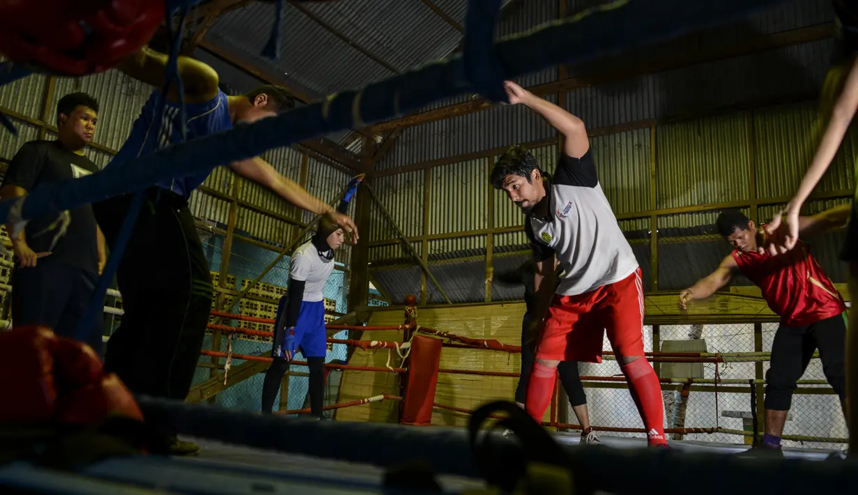Para petinju melakukan peregangan setelah mengikuti sesi latihan di sebuah pusat olahraga di Banda Aceh (24/8/2020). (AFP Photo/Chaideer Mahyuddin)