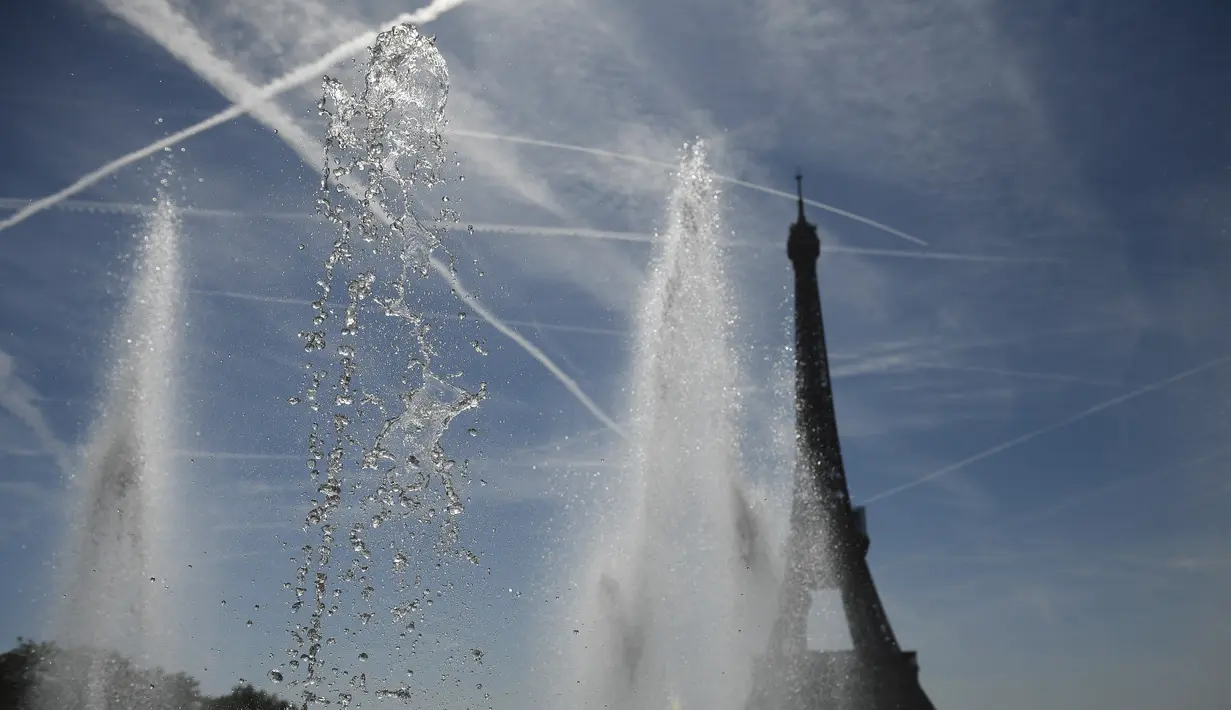 <p>Sebuah foto menunjukkan semburan air di dekat air mancur Trocadero dekat Menara Eiffel, di tengah suhu tinggi di Paris, Kamis (16/6/2022). Prancis akan mengalami suhu yang memecahkan rekor mendekati 40 derajat Celcius pada Juni, karena gelombang panas dini yang diperkirakan akan melanda sebagian besar negara itu. (JULIEN DE ROSA / AFP)</p>