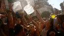 Orang-orang menadahkan air untuk saling siram saat mengikuti perang air tahunan di daerah Vallecas di Madrid, Spanyol (16/7). Perang air ini diikuti oleh ribuan orang, di wilayah Madrid dan sekitarnya. (AP Photo / Francisco Seco)