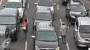 Pedagang asongan menjajakan dagangannya di tengah kemacetan kawasan Harmoni, Jakarta, Selasa (19/4). Kemacetan yang semakin parah di Ibukota menjadi keuntungan tersendiri bagi para pedagang asongan untuk mencari nafkah. (Liputan6.com/Immanuel Antonius)