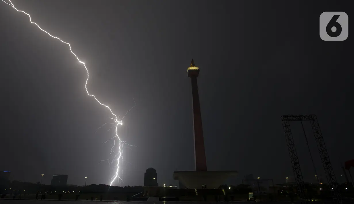 Kilatan petir menyambar di kawasan Monas, saat hujan yang disertai angin mengguyur Jakarta, Sabtu (21/12/2019),Malam. BMKG mengingatkan agar waspada terhadap potensi hujan deras yang disertai petir diprediksi akan terjadi dalam beberapa hari kedepan. (merdeka.com/Imam Buhori)