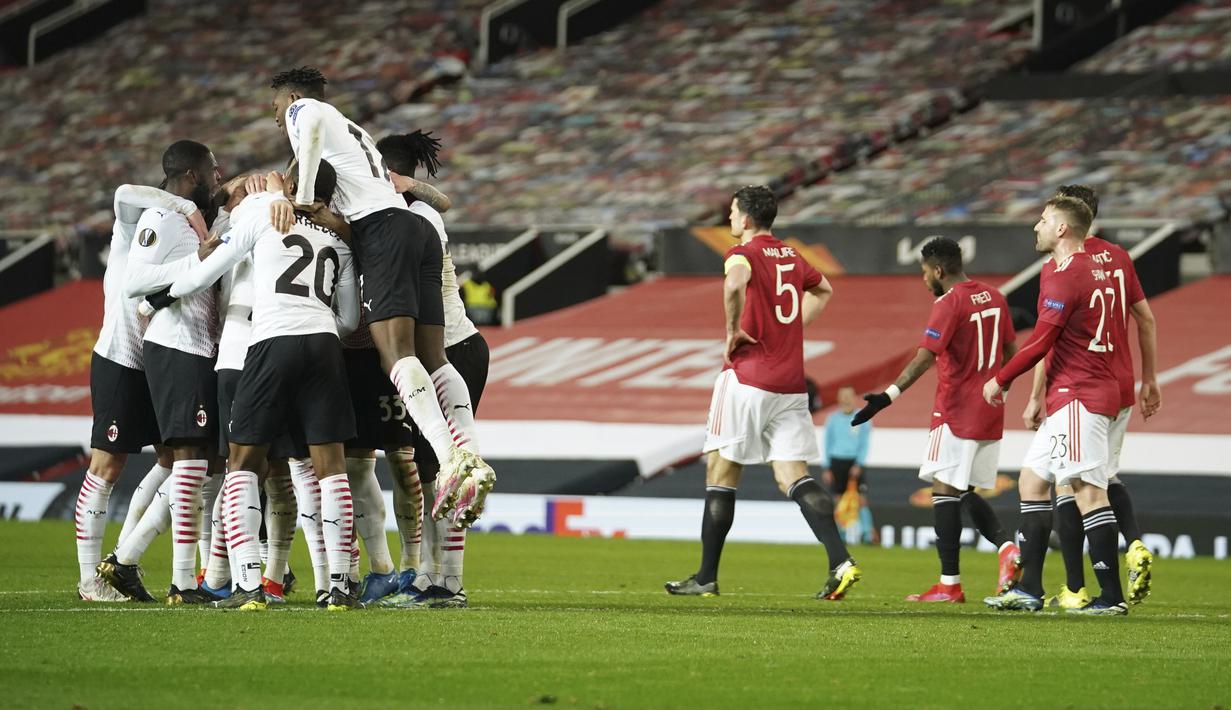 Para pemain AC Milan melakukan selebrasi setelah bek Simon Kjaer mencetak gol di menit 90+2 ke gawang Manchester United pada pertandingan leg pertama babak 16 besar Liga Europa di Old Trafford, Inggris, Jumat (12/3/2021). MU bermain imbang atas AC Milan 1-1. (AP Photo/Dave Thompson)