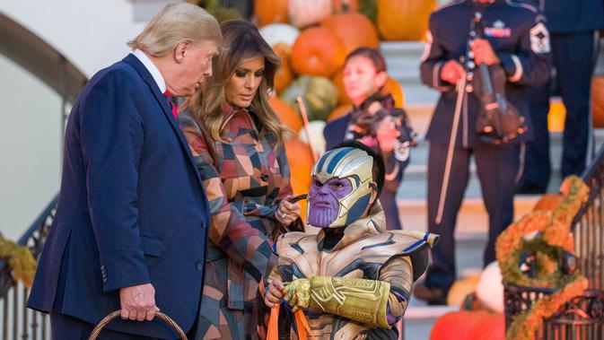 Halloween Ala Trump: Presiden Donald Trump dan ibu negara Melania Trump membagikan permen kepada anak-anak selama acara trick-or-treat Halloween di Gedung Putih, 28 Oktober 2019. Halloween memang menjadi salah satu perayaan terbesar di banyak negara di seluruh dunia. (AP/Alex Brandon)