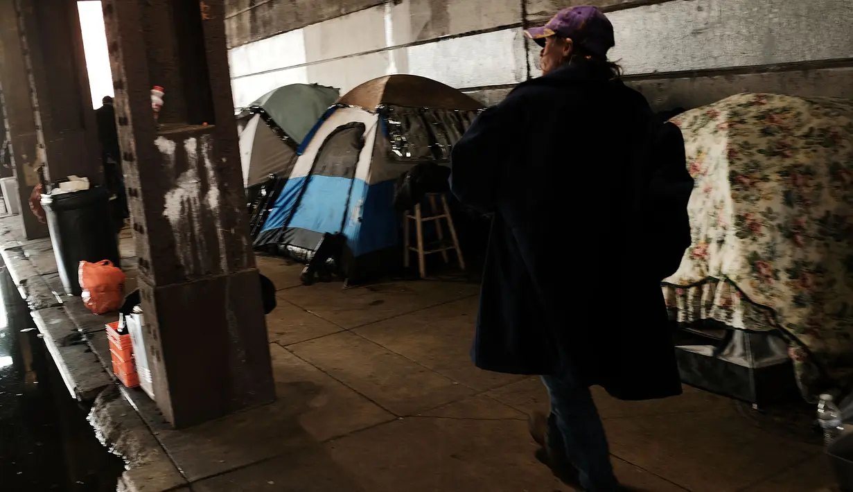 Seorang pria berjalan di dekat tenda-tenda tempat tinggal pecandu heroin di Kensington, Philadelphia (24/1). Menurut DAE Amerika Serikat, penggunaan heroin telah berlipat ganda di seluruh negeri sejak 2010. (Spencer Platt/Getty Images/AFP)
