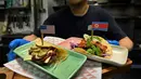 Koki menyajikan makanan taco bernama El Trumpo dan Rocket Man di restoran Lucha Loco, Singapura, 7 Juni 2018. Makanan itu memanfaatkan momentum pertemuan Donald Trump dan Pemimpin Korea Utara Kim Jong-un di Singapura 12 Juni nanti. (AFP/ROSLAN RAHMAN)