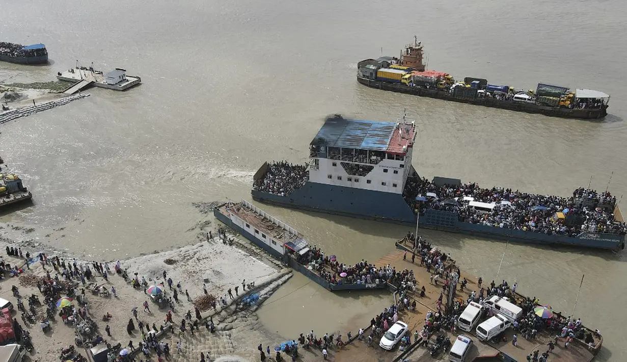 Foto udara yang diambil pada 27 Juni 2021 ini memperlihatkan penumpang naik kapal feri jelang pengetatan lockdown, Munshiganj, Bangladesh. Kasus infeksi COVID-19 di Bangladesh sempat menurun pada Mei tetapi mulai meningkat lagi bulan ini. (Munir Uz zaman/AFP)