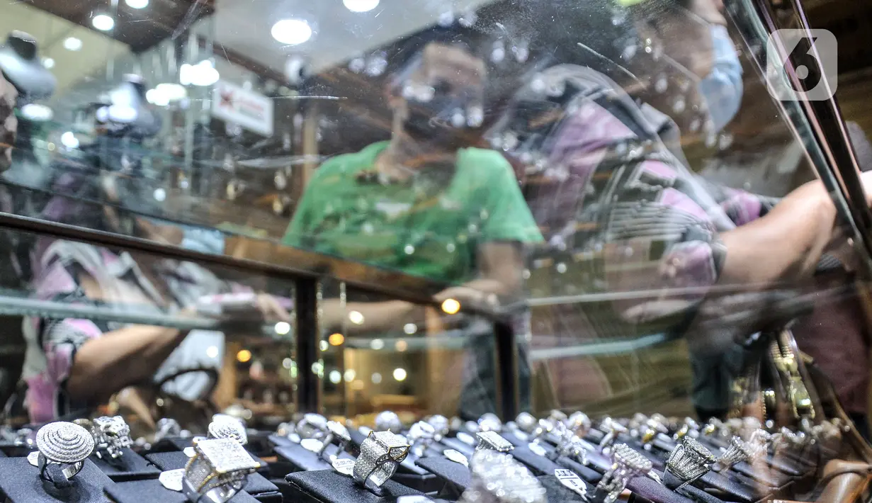 Penjual melayani calon pembeli berlian di toko perhiasan di Pasar Rawa Bening, Jatinegara, Jakarta, Kamis (11/11/2021). Pemilik toko mengatakan pandemi COVID-19 membuat daya beli masyarakat terhadap berlian turun hingga 50 persen. (merdeka.com/Iqbal S. Nugroho)