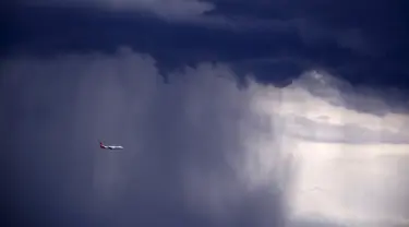 Sebuah pesawat melintasi awan gelap dengan  hujan lebat disertai badai menuju arah Sydney, Australia, Jumat (6/11/2015). Menurut Badan Meteorologi Australia akan ada badai besar diserta hujan lebat yang akan mengguncang Australia. (REUTERS/David Gray) 