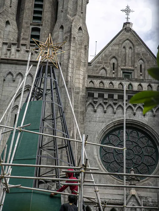 Pekerja menyelesaikan pembuatan pohon Natal di Gereja Katedral, Jakarta pada Rabu (16/12/2020). Gereja Katedral Jakarta membuat pohon natal dengan tinggi lebih dari 10 meter dalam rangka menyambut perayaan Natal. (Liputan6.com/Faizal Fanani)