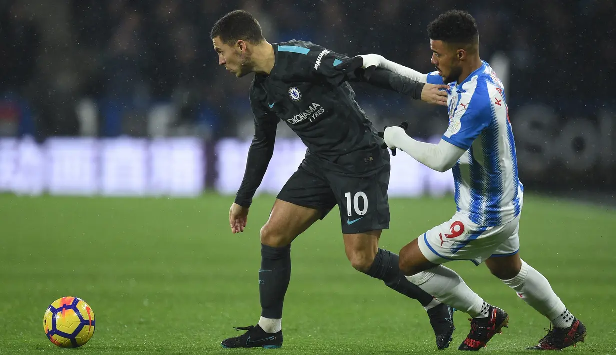 Gelandang Chelsea Eden Hazard berusaha merebut bola dari pemain Huddersfield Town, Elias Kachunga pada lanjutan pertandingan Premier League di Stadion The John Smith's, Selasa (12/12). Chelsea berhasil mengalahkan Huddersfield Town 3-1. (Oli SCARFF / AFP)
