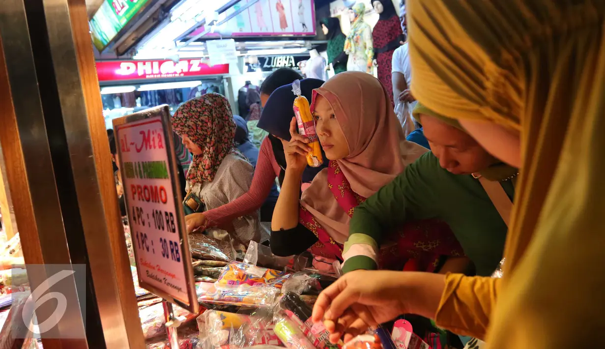 Seorang pembeli saat memilih barang di pusat perbelanjaan Tanah Abang, Jakarta, Sabtu (25/6). Jelang lebaran banyak masyarakat yang sudah berburu kebutuhan pakaian baru. (Liputan6.com/Angga Yuniar)