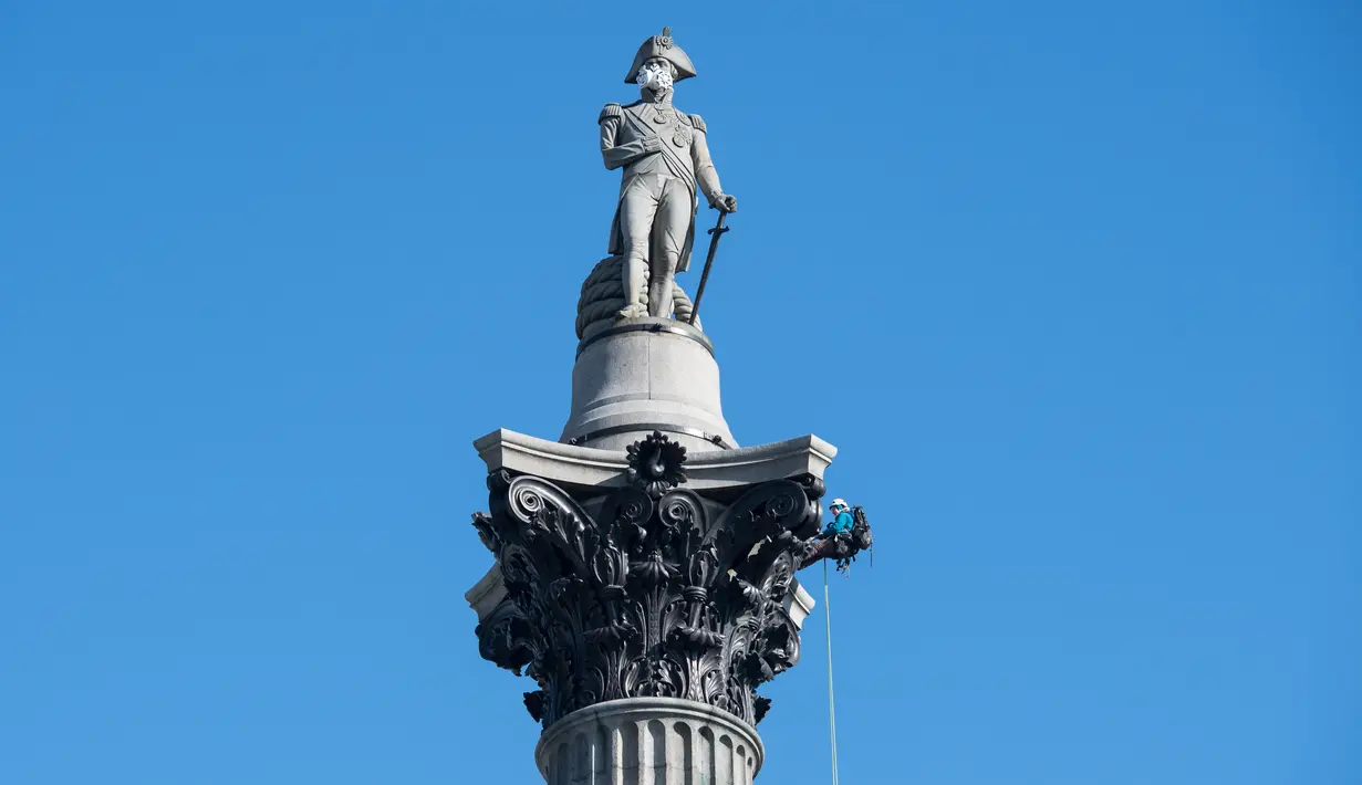 Aktivis lingkungan Greenpeace memasangkan masker pada wajah patung Nelson's Column di Trafalgar Square, pusat kota London, Senin (18/4). Aksi unik itu dilakukan untuk memprotes kualitas polusi udara di kawasan tersebut. (Leon NEAL/AFP)