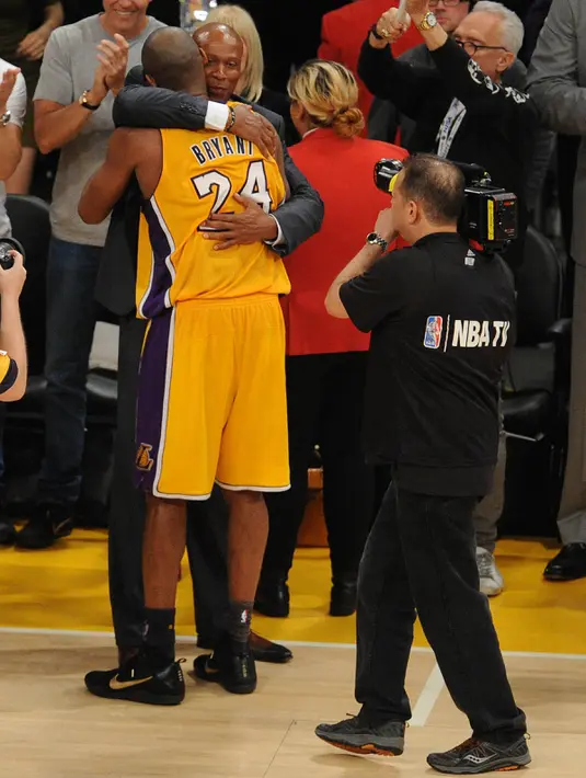 Pemain Los Angeles Lakers, Kobe Bryant memeluk pelatihnya usai pertandingan antara Lakers melawan Utah Jazz di Staples Center, AS, (13/4).Pebasket NBA tersebut menyatakan pensiun dari NBA setelah 20 tahun berkarir. (Gary A. Vasquez-USA TODAY Sports)
