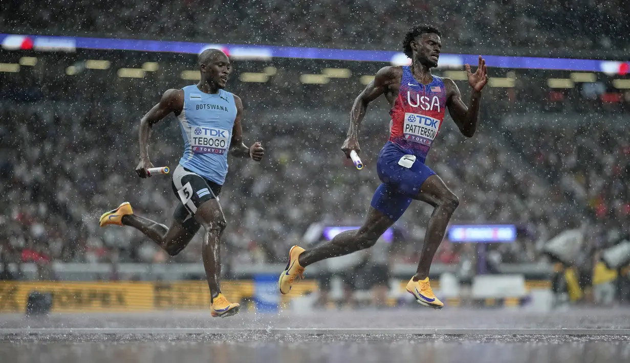 Pelari Amerika Serikat, Jacory Patterson (kanan) dan pelari Botswana, Letsile Tebogo (kiri) berkompetisi dalam nomor estafet 4 x 400 meter putra di Kejuaraan Dunia Atletik di Tokyo, Jepang, Minggu (21/09/2025). (AP Photo/Louise Delmotte)