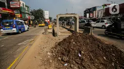 Pengendara melintas di dekat proyek pembangunan saluran air atau drainase di Jalan KH Abdullah Syafei, Jakarta, Selasa (18/7/2023). (Liputan6.com/Faizal Fanani)