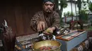 Nasip Hadi Prayitno (51) melakukan ritual jamasan atau pencucian keris di Museum Pusaka TMII, Jakarta, Kamis (20/8/2020). Pencucian keris bertujuan membersihkan karat dari badan keris. (Liputan6.com/Faizal Fanani)