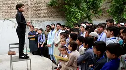 Motivator cilik Hammad Safi berdiri di atas kursi memberikan motivasi kepada para siswa di sebuah akademi bahasa di Peshawar, Pakistan (3/4). Berkat Hammad Safi aksinya di depan umum ia menjadi bintang internet. (AFP/Abdul Majeed)