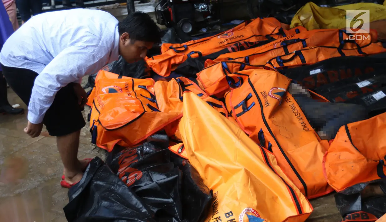Warga melihat jenazah korban gelombang Tsunami Anyer di Puskesmas Carita, Banten, Minggu (23/12). Tim SAR masih melakukan pencarian jenazah yang sebagian besar berasal dari Pantai Carita. (Liputan6.com/Angga Yuniar)