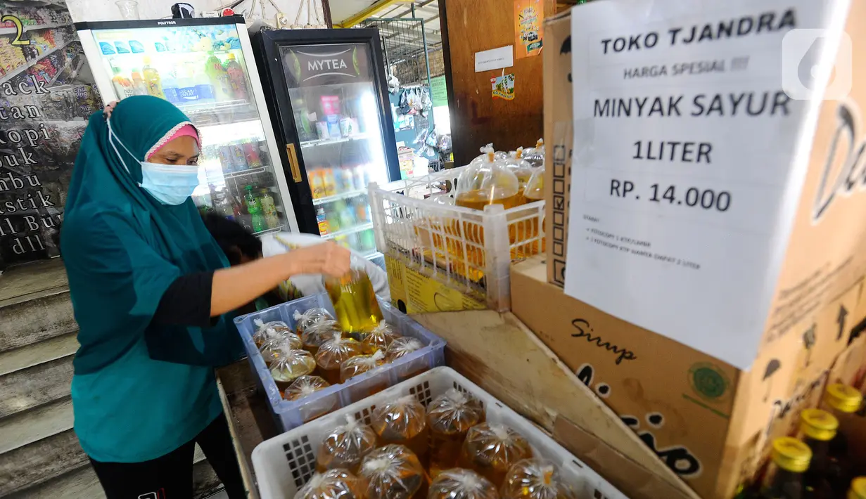 Warga membeli minyak goreng curah di Toko Tjandra, Cinere, depok, Jumat (03/06/2022). Paska dicabutnya kebijakan subsidi minyak goreng curah, pembeli minyak goreng curah di pasaran diwajibkan menyertakan kartu tanda penduduk (KTP) dengan maksimal 1 ktp untuk 2 liter minyak goreng curah seharga Rp 14.000/liter. (merdeka.com/Arie Basuki)