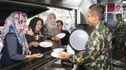 Prajurit Korps Marinir TNI AL memberikan nasi goreng gratis ke warga saat car free day di Jakarta, Minggu (5/11). Kegiatan bagi-bagi nasi goreng ini dalam rangka menyambut HUT Marinir ke-72. (Liputan6.com/Angga Yuniar)