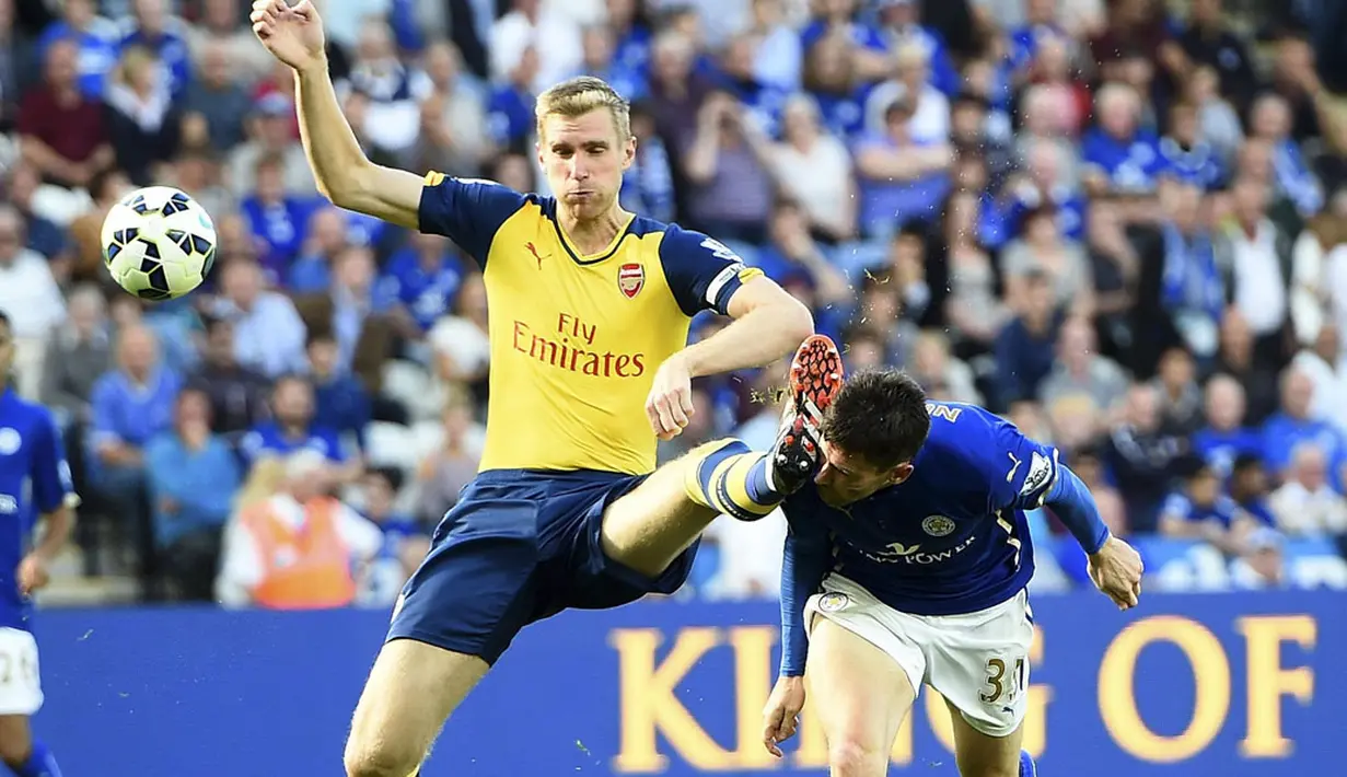Pemain depan Leicester City, David Nugent (kanan), mencium sepatu bek Arsenal, Per Mertesacker, di laga lanjutan Liga Primer Inggris 2014-2015 di Stadion King Power, (31/8/2014). (REUTERS/Dylan Martinez)