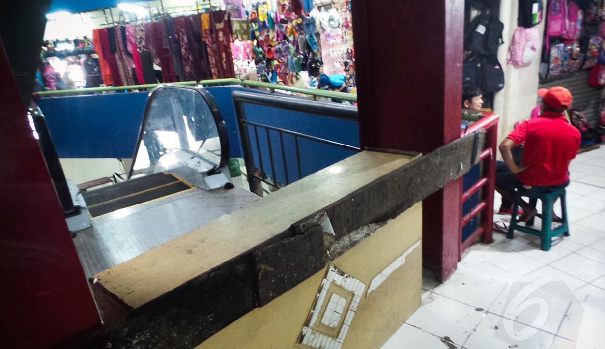 Seorang pedagang duduk disamping eskalator yang belum beroperasi di Pasar Blok G Tanah Abang, Jakarta, (26/8/2014). (Liputan6.com/Faizal Fanani)