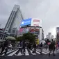 Orang-orang mengenakan masker untuk mencegah virus corona berjalan melintasi penyeberangan pejalan kaki pada awal liburan "Minggu Emas" Jepang di distrik Shibuya, Tokyo, Kamis (29/4/2021). Pemerintah Jepang meminta warga untuk tinggal di rumah selama "minggu emas". (AP Photo/Eugene Hoshiko)