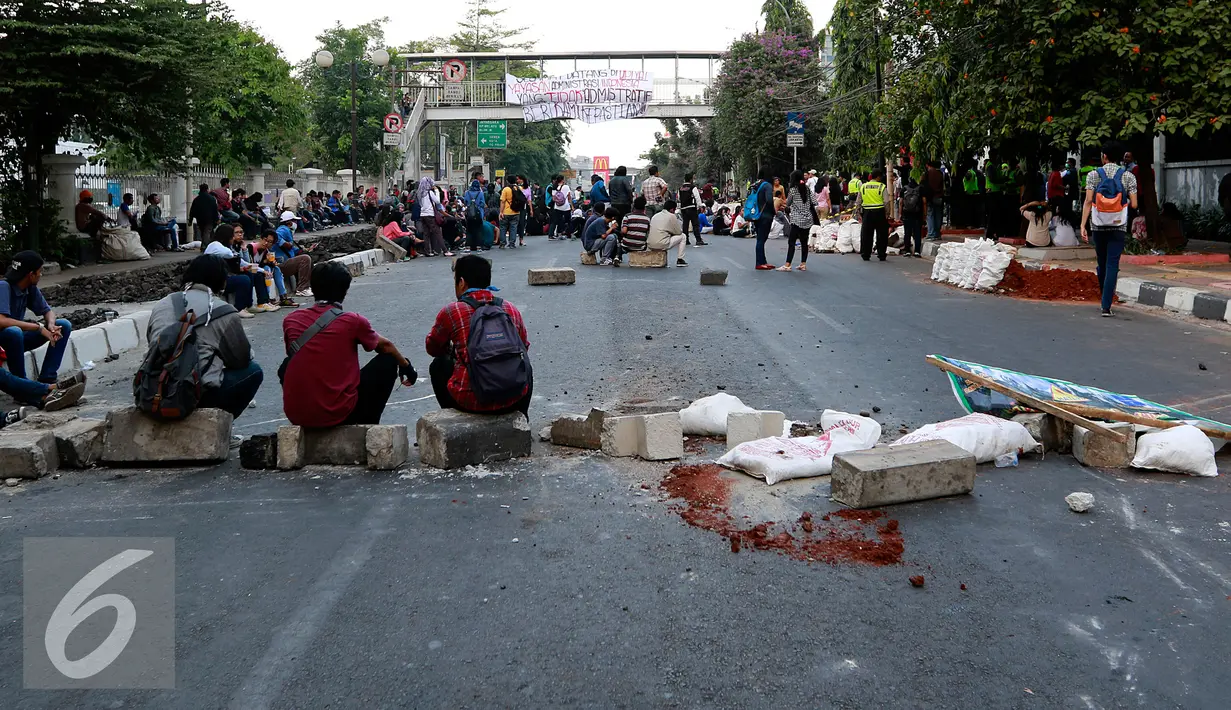 Mahasiswa membentuk blokade serta menutup jalan Diponegoro dengan meletakkan batu, Jakarta, Selasa (27/10/2015). Mereka menuntut rektor UPI YAI mundur dari jabatannya karena menutupi skandal penipuan terhadap 1.080 mahasiswa. (Liputan6.com/Yoppy Renato)