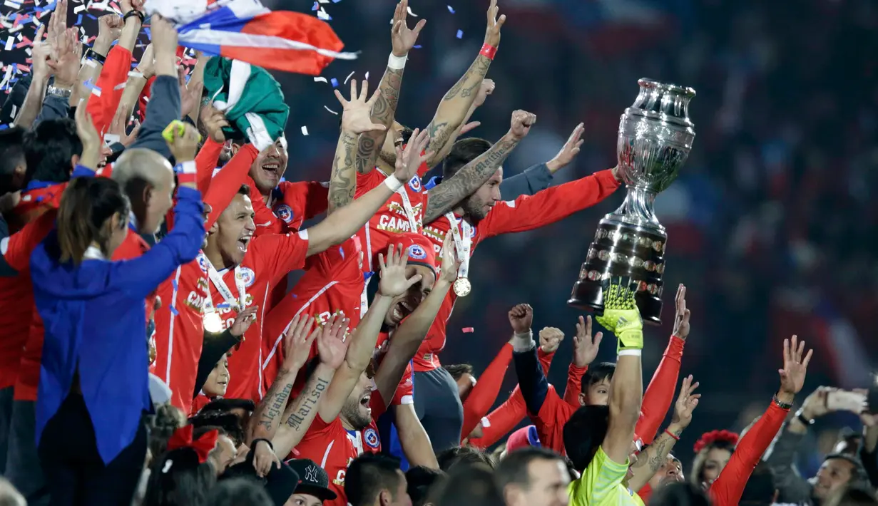 Para pemain Chili bersorak mengangkat trofi usai mengalahkan Argentina saat Final Copa America 2015 di Stadion Nasional, Santiago, Chili, (4/7/2015). Chili menang lewat adu penalti atas Argentina dengan skor 4-1. (REUTERS/Jorge Adorno)