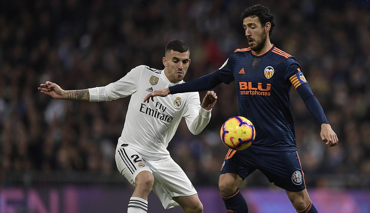 Gelandang Real Madrid, Daniel Ceballos, berebut bola dengan gelandang Valencia, Daniel Parejo, pada laga La Liga di Stadion Santiago Bernabeu, Madrid, Sabtu (1/12). Madrid menang 2-0 atas Valencia. (AFP/Oscar Del Pozo)