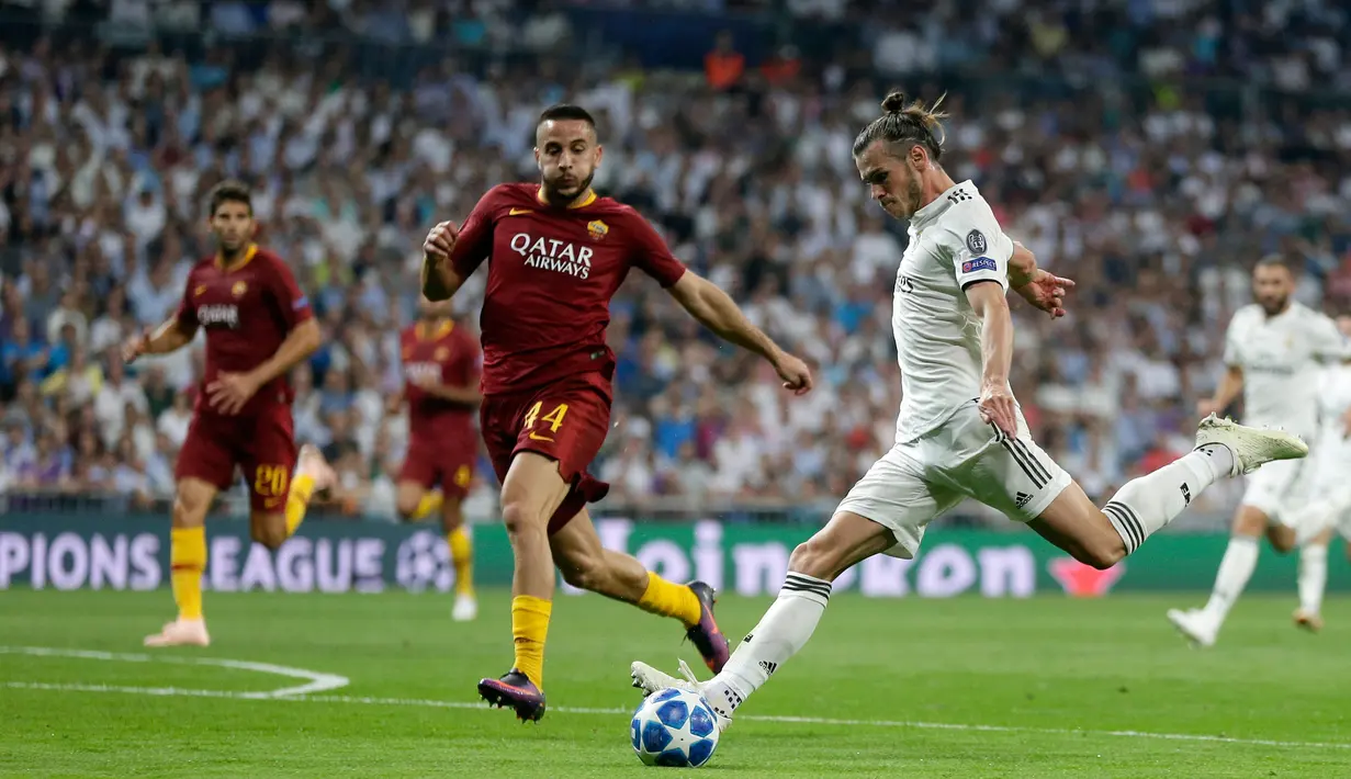 Gelandang Real Madrid, Gareth Bale (tengah) menendang bola ke gawang AS Roma pada pertandingan Grup G Liga Champions di Stadion Santiago Bernabeu, Madrid, Spanyol, Rabu (19/9). Madrid membantai Roma 3-0. (AP Photo/Manu Fernandez)