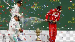 Lewis Hamilton bersama Valterri Bottas dan Kimi Raikkonen melakukan selebrasi di atas podium Sirkuit Silverstone, Minggu (16/7/2017). Pebalap asal Inggris itu melahap 51 lap dengan catatan waktu 1 jam 21 menit 27,430 detik. (EPA/Geoff Caddick)