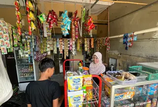 Ernawati Sedang Melayani Pelanggan di Warung Sembakonya (Supriatin/Liputan6.com)