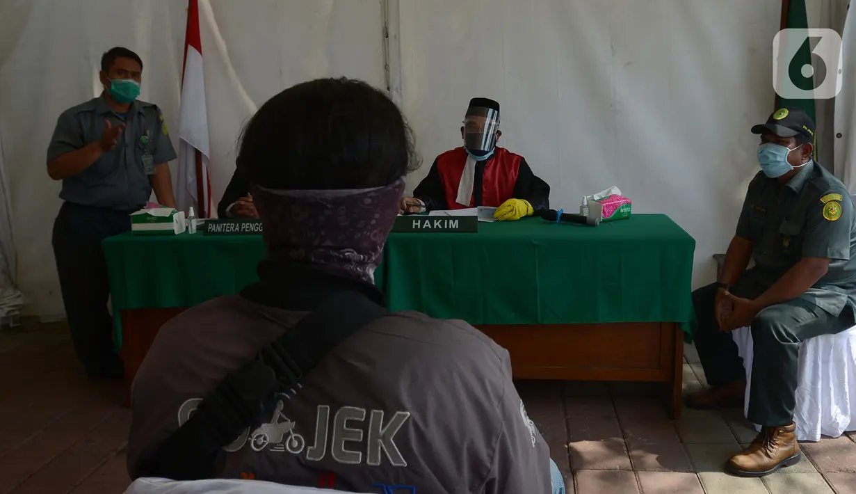 Pelanggar mengikuti sidang di tempat saat Operasi Yustisi di Kawasan Danau Sunter, Jakarta, Rabu (16/9/2020). Warga yang melanggar protokol Covid-19 langsung disidang tindak pidana ringan (tipiring) di tempat dengan membayar denda Rp 55.000 maupun sanksi sosial. (merdeka.com/Imam Buhori)