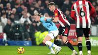 Nathan Collins membayangi Erling Haaland dalam laga Premier League antara Brentford vs Manchester City, Rabu (15/1/2025). (c) AP Photo/Alastair Grant