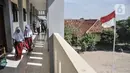 Murid membuka sepatu sebelum memasuki ruang kelas di Sekolah Dasar Negeri (SDN) Mekarsari 05, Tambun Selatan, Kabupaten Bekasi, Jawa Barat, Kamis (28/7/2022). Para guru di SDN Mekarsari 05 berharap pemerintah Kabupaten Bekasi melalui Dinas Pendidikan segera menyediakan meja dan kursi agar lebih layak seperti sekolah pada umummnya. (merdeka.com/Iqbal S. Nugroho)