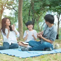 Sebuah keluarga kecil yang terdiri dari ayah, ibu, dan seorang anak laki-laki sedang mengadakan piknik di taman (Foto Dok: Freepik/mkitina4).