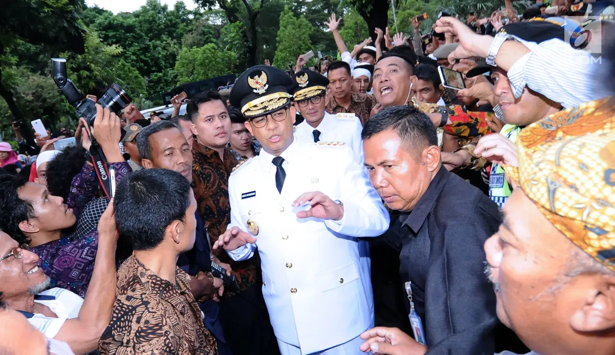 Gubernur DKI Jakarta. Anies Baswedan dikawal ketat saat akan masuk Balai Kota, Senin (16/10). Ribuan warga menyambut kedatangan Anies Baswedan dan Sandiaga Uno usai dilantik sebagai Gubernur dan Wakil Gubernur. (Liputan6.com/Helmi Fithriansyah)